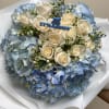 Blue hydrangea bouquet with white roses and a baby boy topper