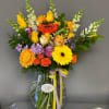 Colorful mixed bouquet in a clear glass vase with ribbon