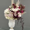 Floral arrangement in a white sculptural vase with pink and white blooms