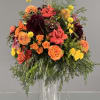 Mixed orange, pink, and yellow bouquet in a clear glass vase
