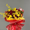 Bouquet of red roses and yellow orchids wrapped in red paper