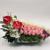 Pink and white roses with red anthuriums in a low white bowl