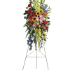 Standing floral spray with roses, lilies, sunflowers, and blue delphinium