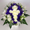White roses and purple flowers in a white vase
