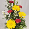 Mixed yellow and red flowers arranged in a mug labeled Get Well