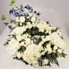 A serene circular wreath of white hydrangea and white roses creates a