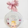 Round memorial plaque with a pink ribbon bow and candle design