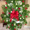 Standing floral spray with red and white roses and a red ribbon