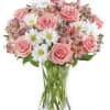Pink roses and white daisies in a clear glass vase