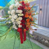 Large standing floral spray with white, red, and orange roses