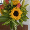 Sunflowers and red roses in a clear glass vase