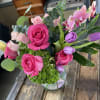 Bouquet of pink roses and purple tulips in a clear glass vase