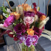 Bouquet of purple, orange, and pink flowers in a glass vase