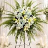 Large standing floral spray with white lilies, blue hydrangeas, and ferns