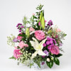 Pink and white mixed flower arrangement in a white basket