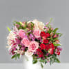 Mixed pink and red flower arrangement in a white vase