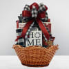 Gift basket with snacks and a HOME sign, topped with a red and plaid bow