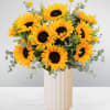 Bouquet of sunflowers in a tall cream vase