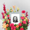 Framed black-and-white portrait surrounded by pink, orange, and yellow flowers