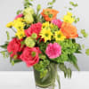 Mixed bouquet of roses, daisies, and carnations in a glass vase