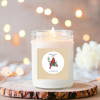 Lit scented candle in a glass jar with a cardinal label
