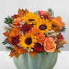 Autumn bouquet of sunflowers, roses, and mums in a pumpkin-shaped vase