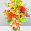 Bouquet of mixed autumn flowers in a glass vase with a patterned ribbon