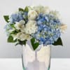 Blue hydrangeas and white roses in a glass vase