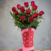 Red roses arranged in a pink cowboy boot vase with heart accents