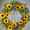 Sunflower wreath with blue flowers on a metal stand