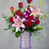 Velvety red roses and fragrant pink stargazer lilies mingle with purple-and-white orchids