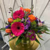 Bright mixed bouquet in a glass vase with pink gerberas and orange roses