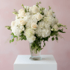 White roses and hydrangeas arranged in a clear glass vase