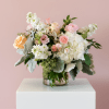 Mixed pink and white flowers arranged in a clear glass vase