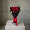 Bouquet of red roses wrapped in black paper with a red ribbon