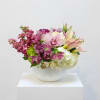 This is a low centerpiece featuring a variety of pink, mauve, and
