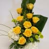 Yellow roses and white hydrangeas in a square vase
