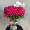 Pink roses in a ribbed glass vase with white orchids
