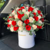 Red and white roses arranged in a white hat box