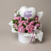 Pink roses and carnations in a white hat box with a birthday balloon