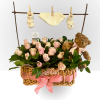 Basket of pale pink roses with a teddy bear and baby booties hanging above on a clothesline