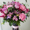 Pink roses and carnations in a purple glass vase