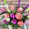 Bouquet of peach roses, lilies, and purple accent flowers