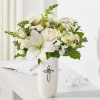 White floral arrangement in a tall vase with a cross emblem