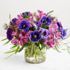 Purple and pink mixed bouquet in a clear glass vase