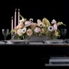 Pink floral centerpiece with candles and gold accent on a table