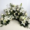 White lilies and roses arranged in a low, wide floral display