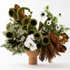 Arrangement of white flowers and sunflowers in a terracotta vase