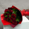 Bouquet of red roses wrapped in red paper with a ribbon