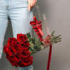 Handheld bouquet of red roses wrapped in clear plastic with a red ribbon